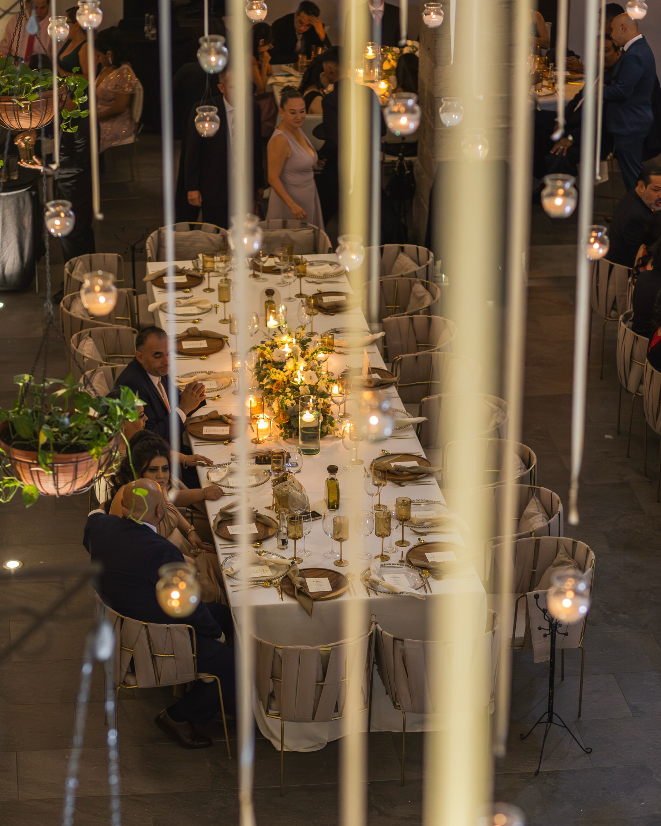 Mesa imperial de boda con velas colgantes en tubos de vidrio sobre el patio del Ex Convento