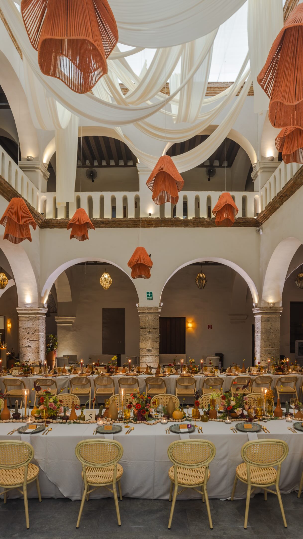 Patio central del Ex Convento montado con mesas largas y lámparas colgantes para una celebración de cumpleaños